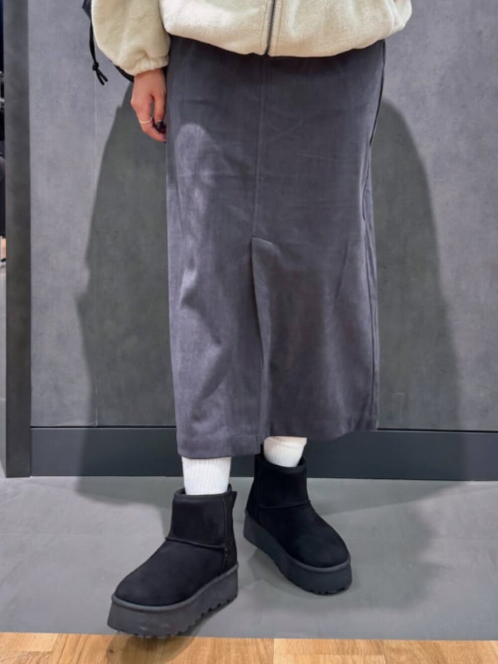 グレー系のスカート、ベージュ系のTシャツ/カットソーを着用したレディースの冬コーディネートの2枚目の写真