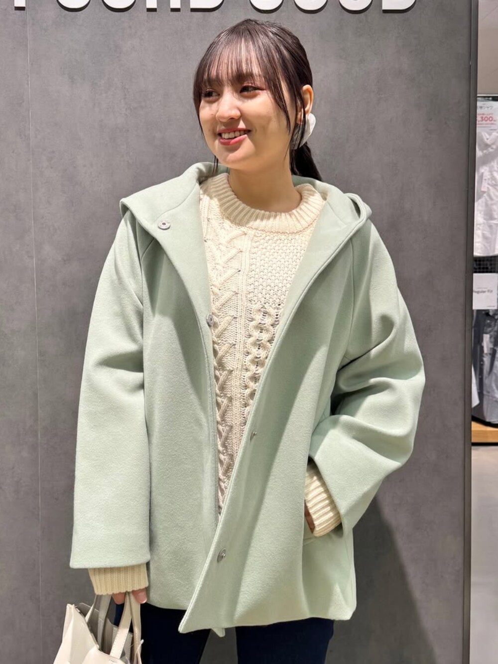 グリーン系のその他アウター、ベージュ系のニット/セーター、グレー系のブーツを着用したレディースの冬コーディネートの2枚目の写真