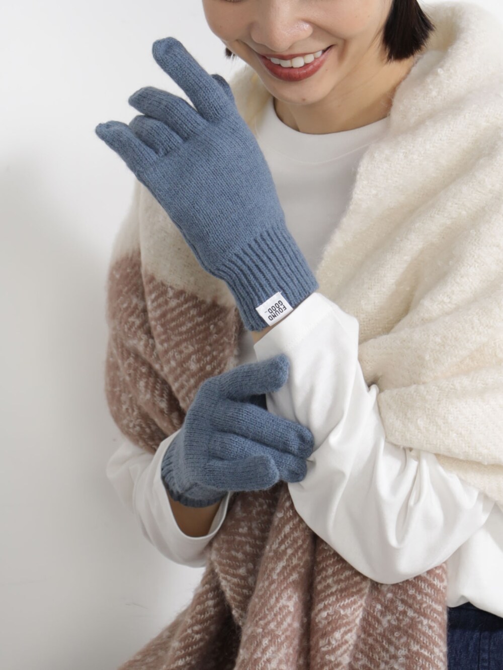 ベージュ系のマフラー、ブルー系のキャップ、ブルー系の手袋を着用したレディースの秋コーディネートの2枚目の写真