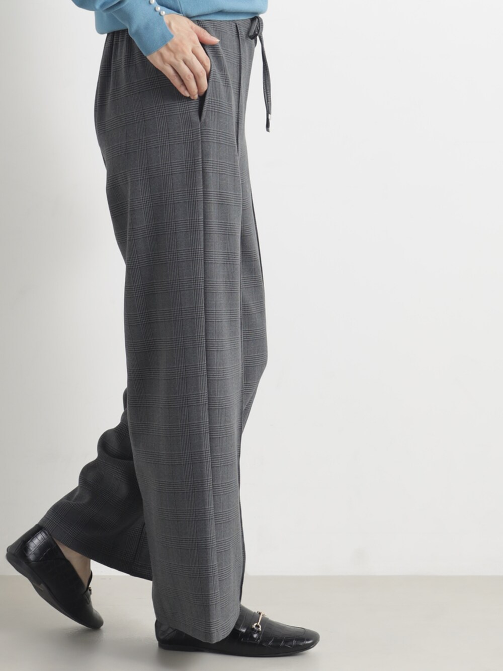 ブルー系のニット/セーター、グレー系のその他パンツを着用したレディースの春コーディネートの3枚目の写真