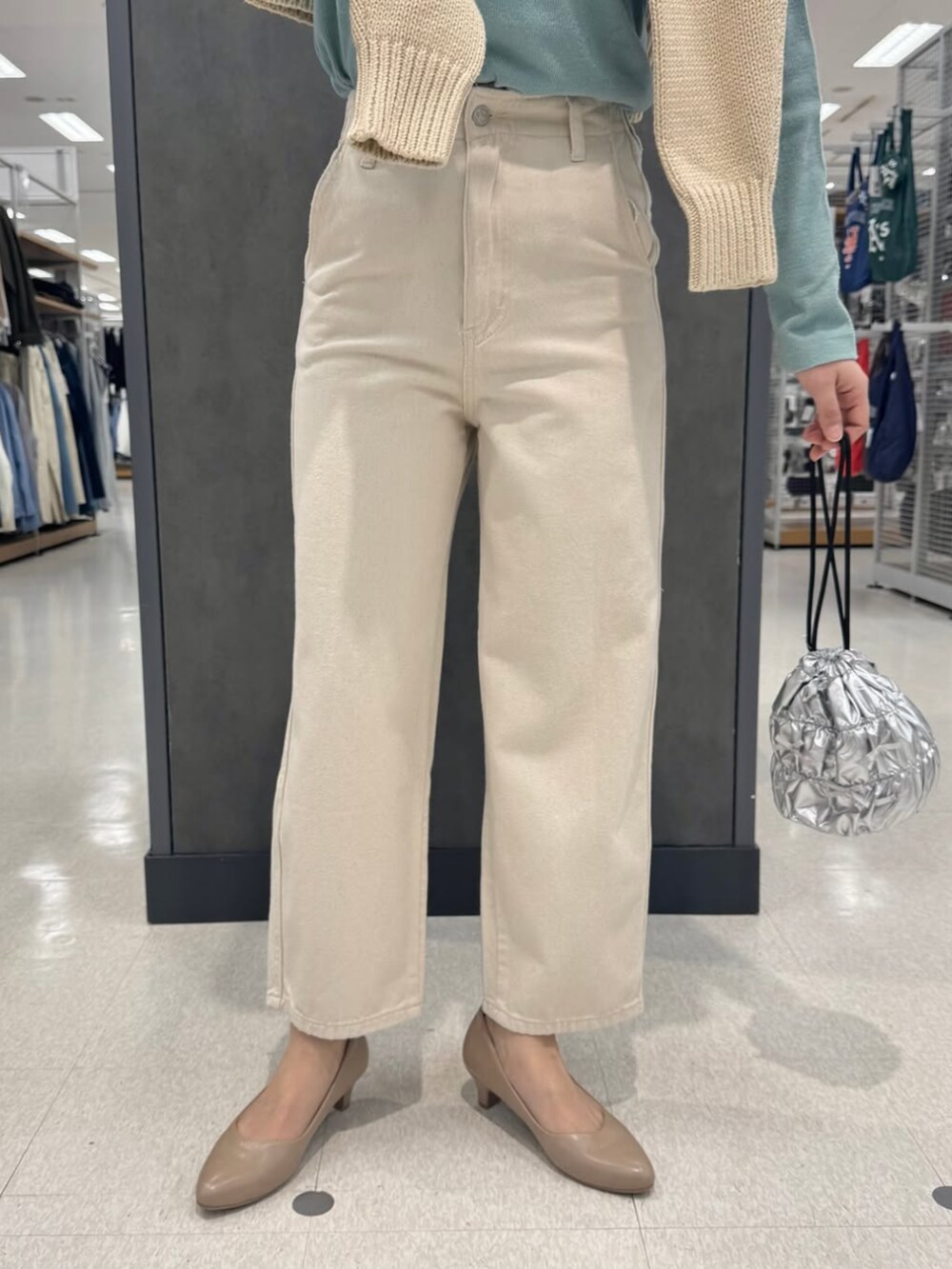 ベージュ系のニット/セーター、ベージュ系のパンプス、ホワイト系のデニムパンツを着用したレディースの冬コーディネートの2枚目の写真