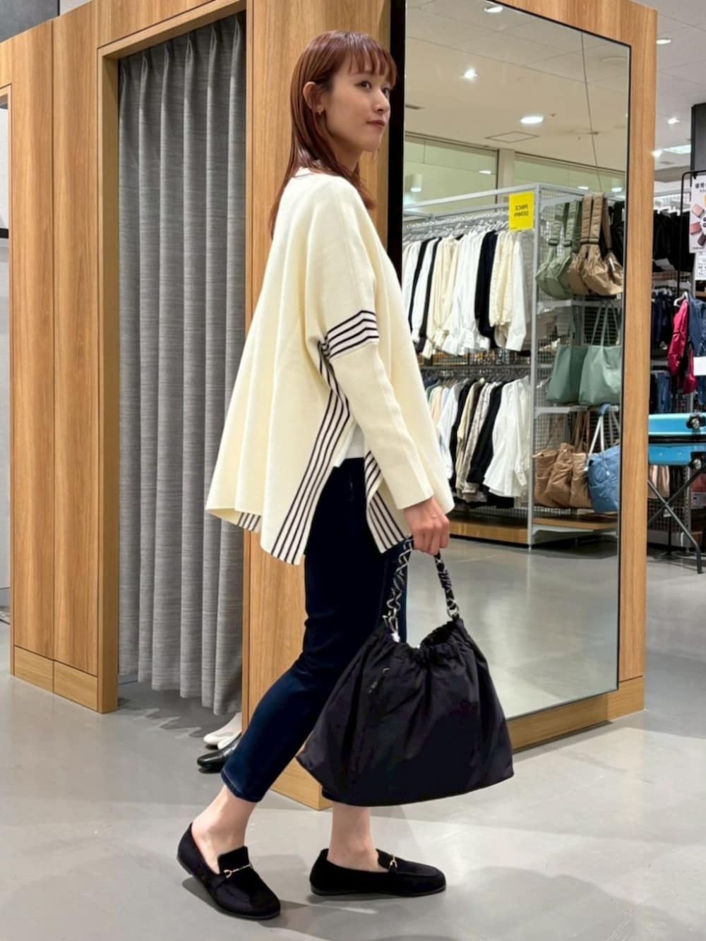 ベージュ系のポンチョを着用したレディースの冬コーディネートの2枚目の写真