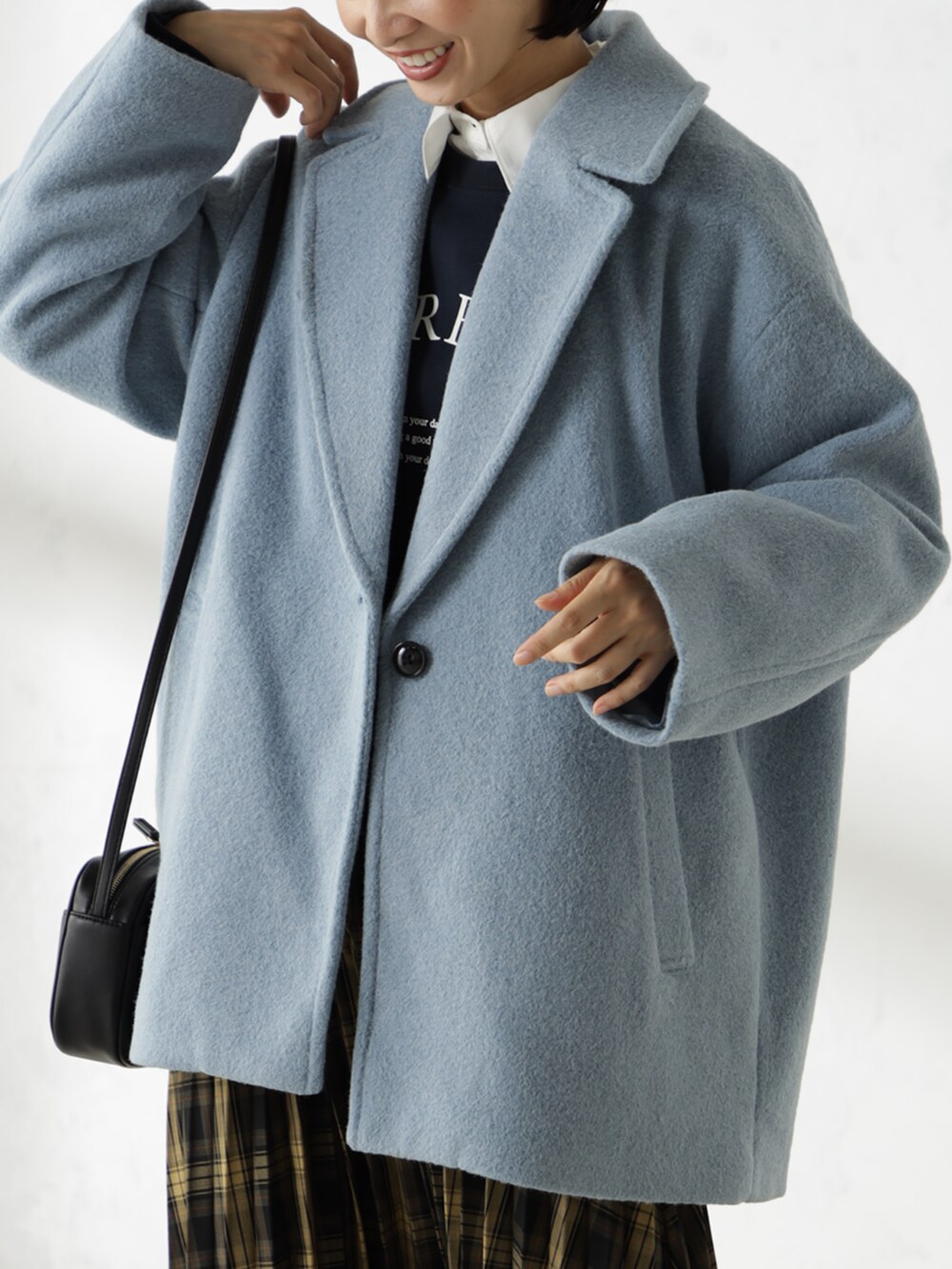 ブラウン系のスカート、ブラック系のショルダーバッグ、ブルー系のその他アウターを着用したレディースの秋コーディネートの2枚目の写真