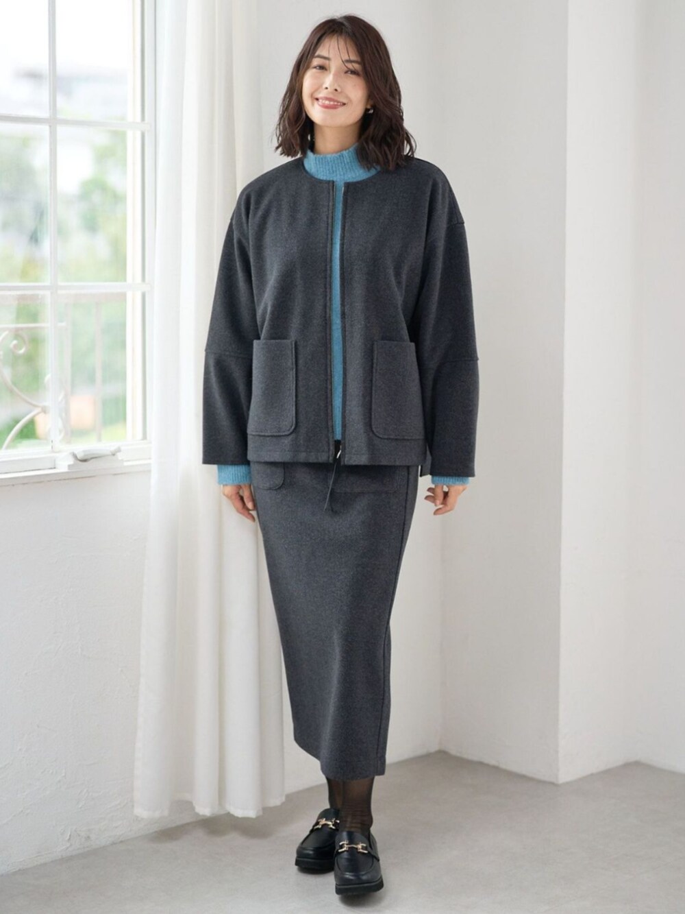 ブルー系のニット/セーターを着用したレディースの秋コーディネートの2枚目の写真