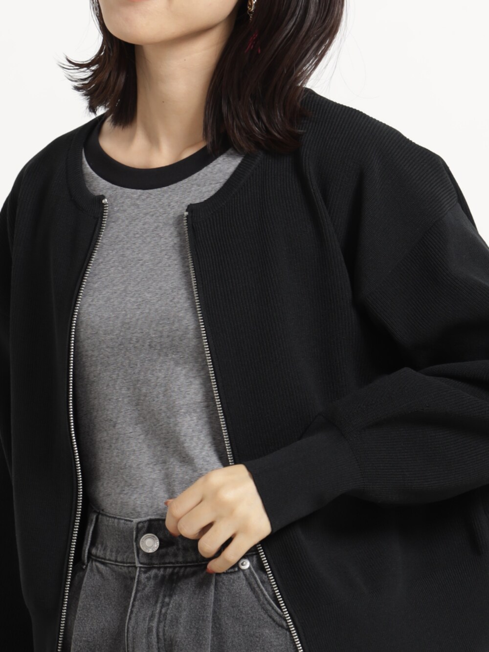 グレー系のデニムパンツ、ブラック系のブルゾンを着用したレディースの秋コーディネートの2枚目の写真