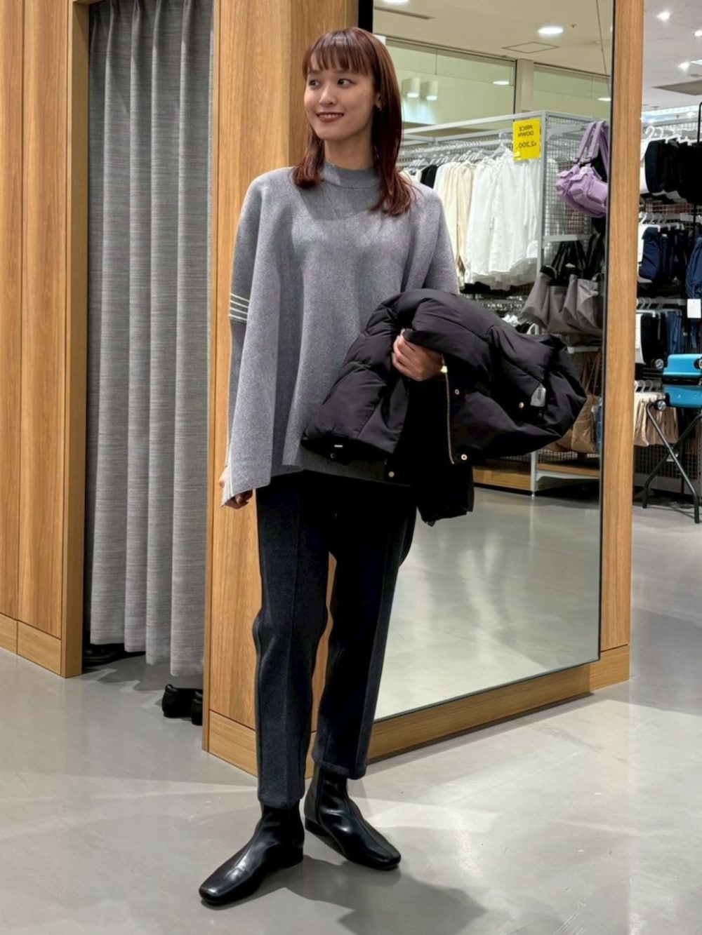 グレー系のポンチョを着用したレディースの冬コーディネートの2枚目の写真