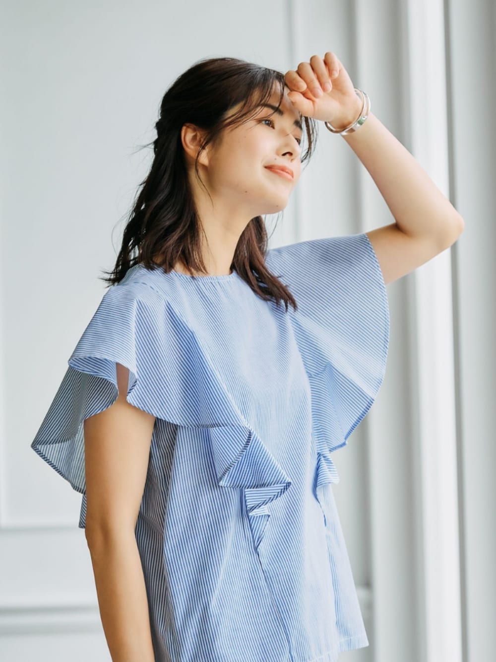 ブルー系のシャツ/ブラウスを着用したレディースの春コーディネートの2枚目の写真