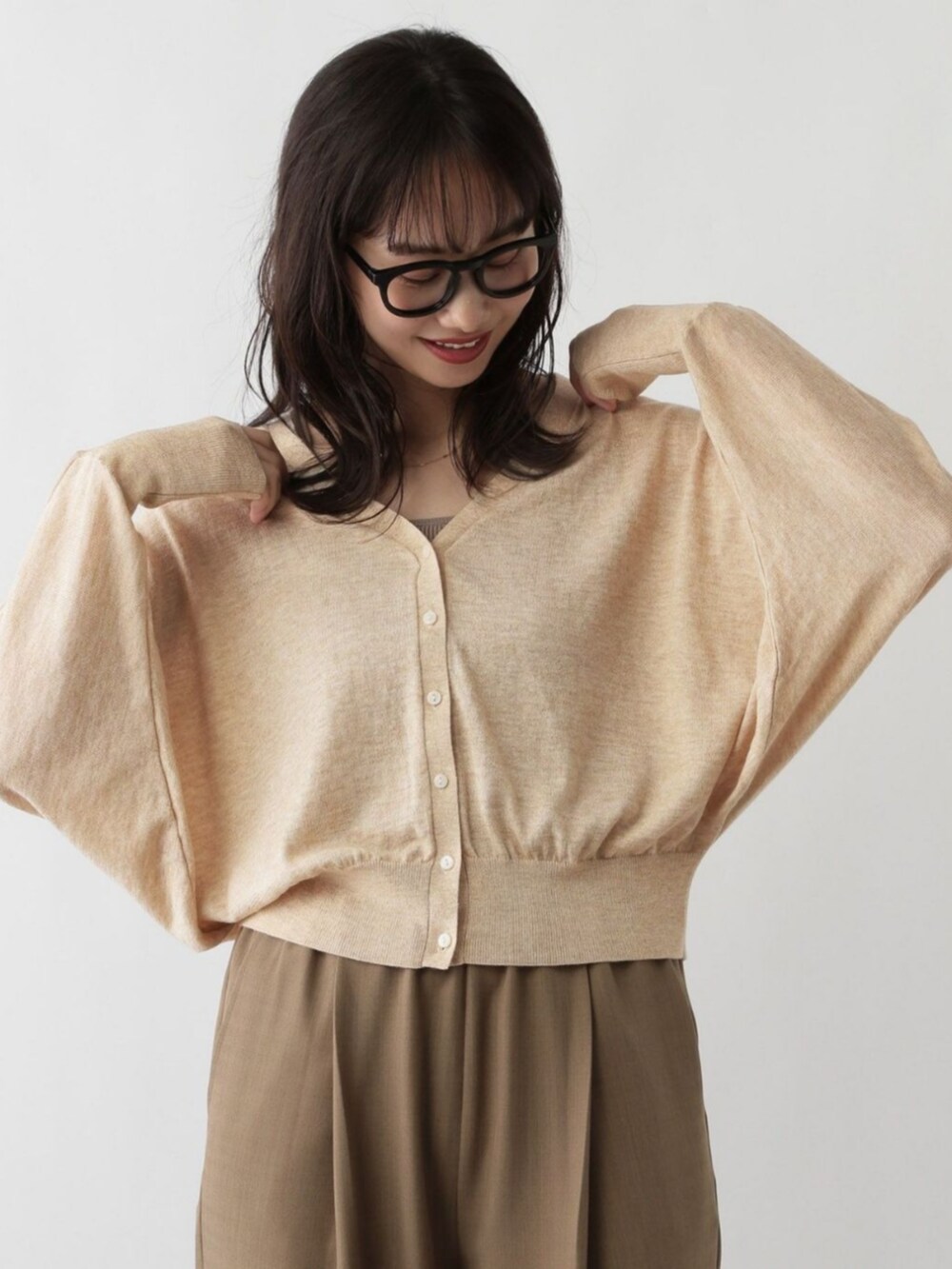 ベージュ系のカーディガン/ボレロを着用したレディースの秋コーディネートの2枚目の写真