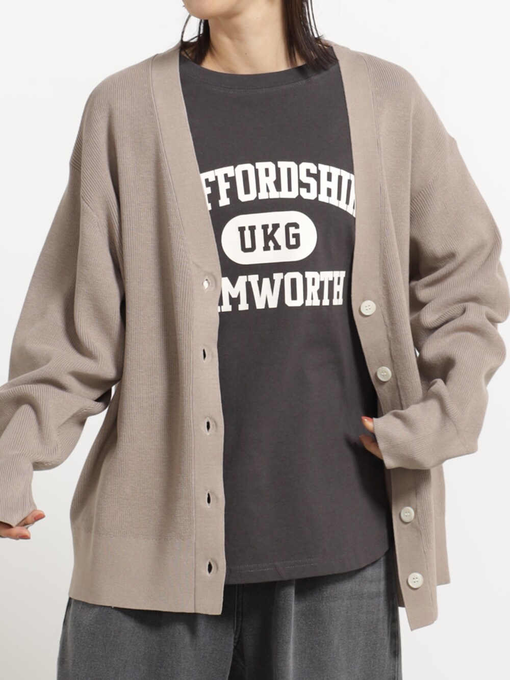 グレー系のデニムパンツ、ベージュ系のカーディガン/ボレロ、グレー系のTシャツ/カットソーを着用したレディースの秋コーディネートの2枚目の写真