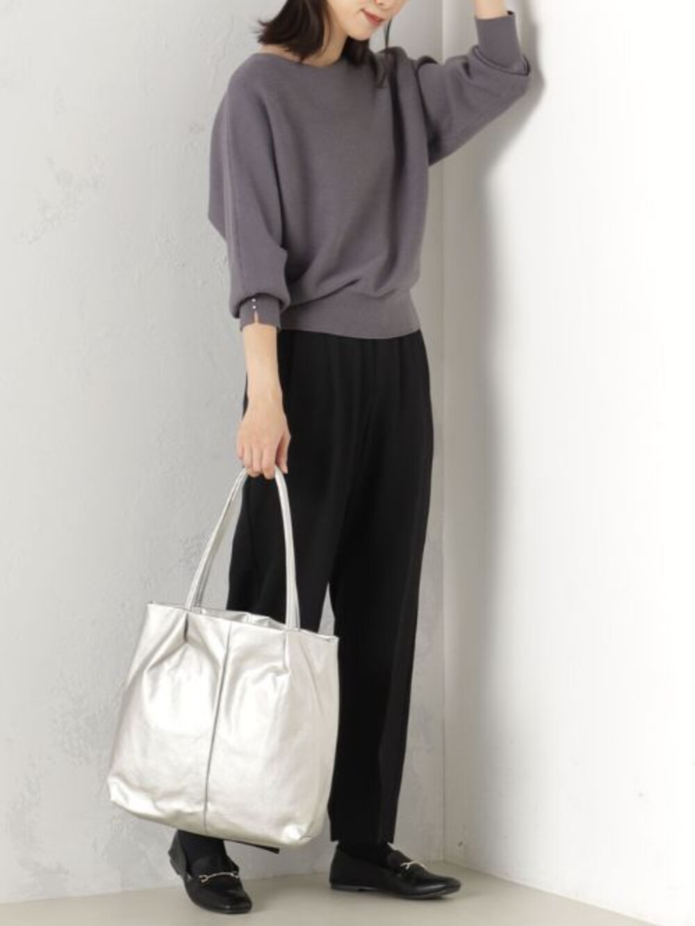 グレー系のニット/セーター、グレー系のトートバッグ、ブラック系のその他パンツを着用したレディースの冬コーディネートの2枚目の写真