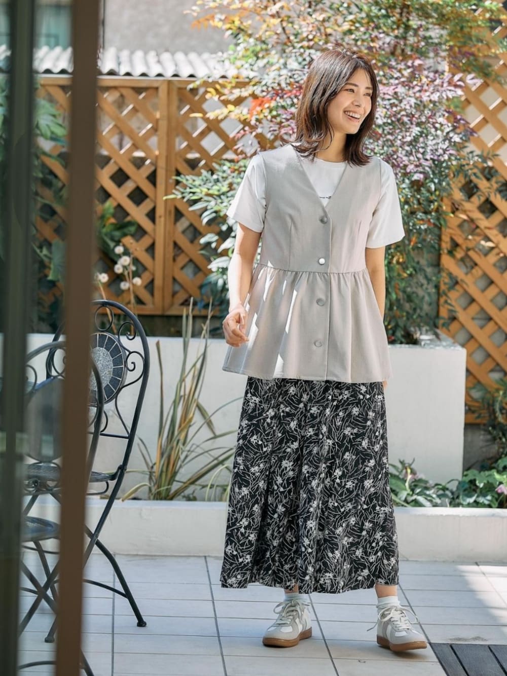 ベージュ系のベストを着用したレディースの春コーディネートの2枚目の写真