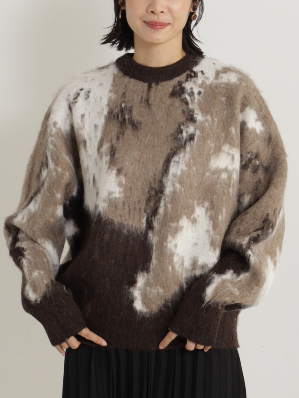 ブラック系のブーツ、ブラック系のショルダーバッグ、ブラック系のスカートを着用したレディースの冬コーディネートの2枚目の写真