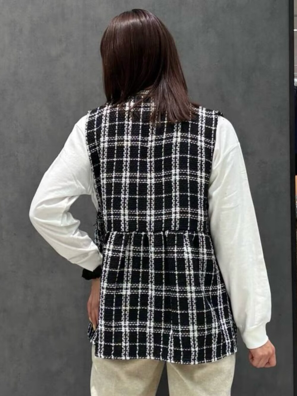 ホワイト系のTシャツ/カットソー、ベージュ系のその他パンツ、ブラック系のベストを着用したレディースの冬コーディネートの2枚目の写真