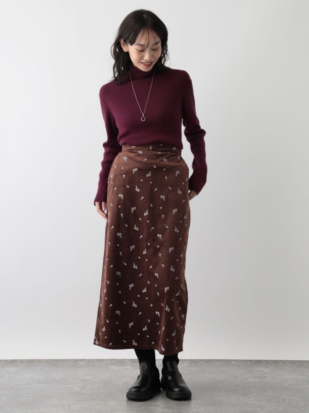 レッド系のニット/セーターを着用したレディースの秋コーディネートの2枚目の写真