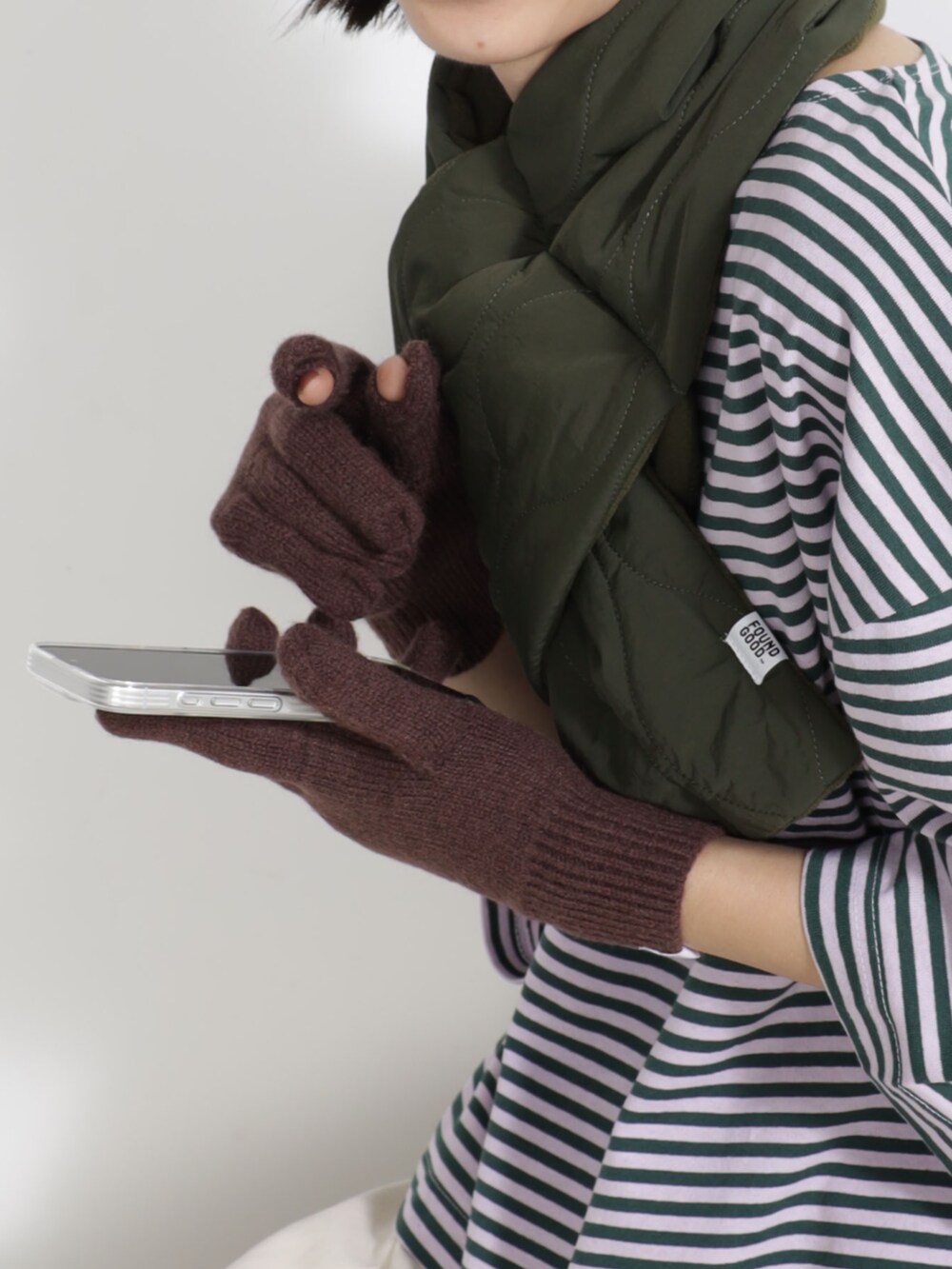 パープル系のTシャツ/カットソー、グリーン系のキャップ、グリーン系のマフラーを着用したレディースの秋コーディネートの2枚目の写真