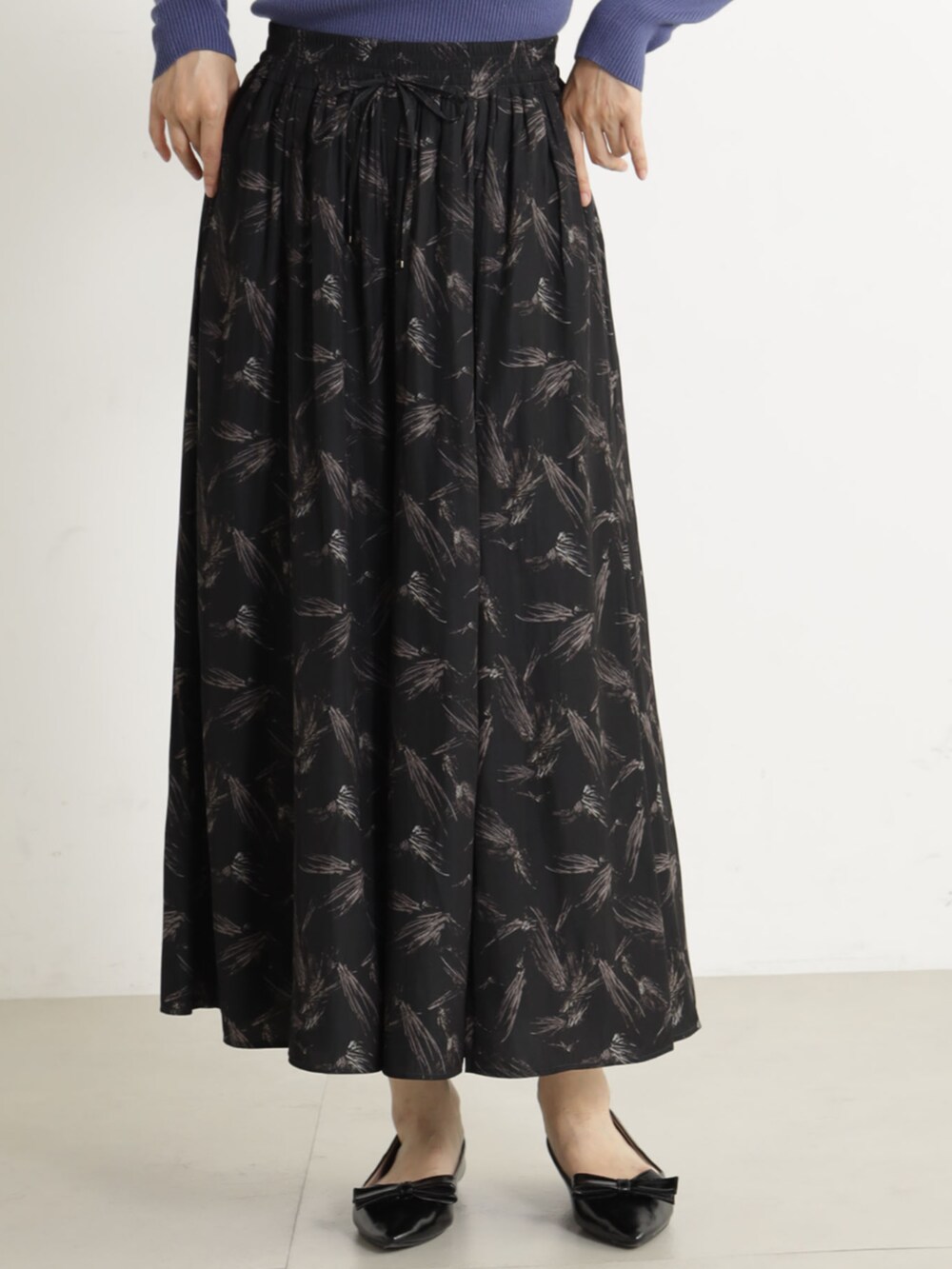 ブラック系のパンプス、ブルー系のニット/セーター、グレー系のその他パンツを着用したレディースの冬コーディネートの2枚目の写真