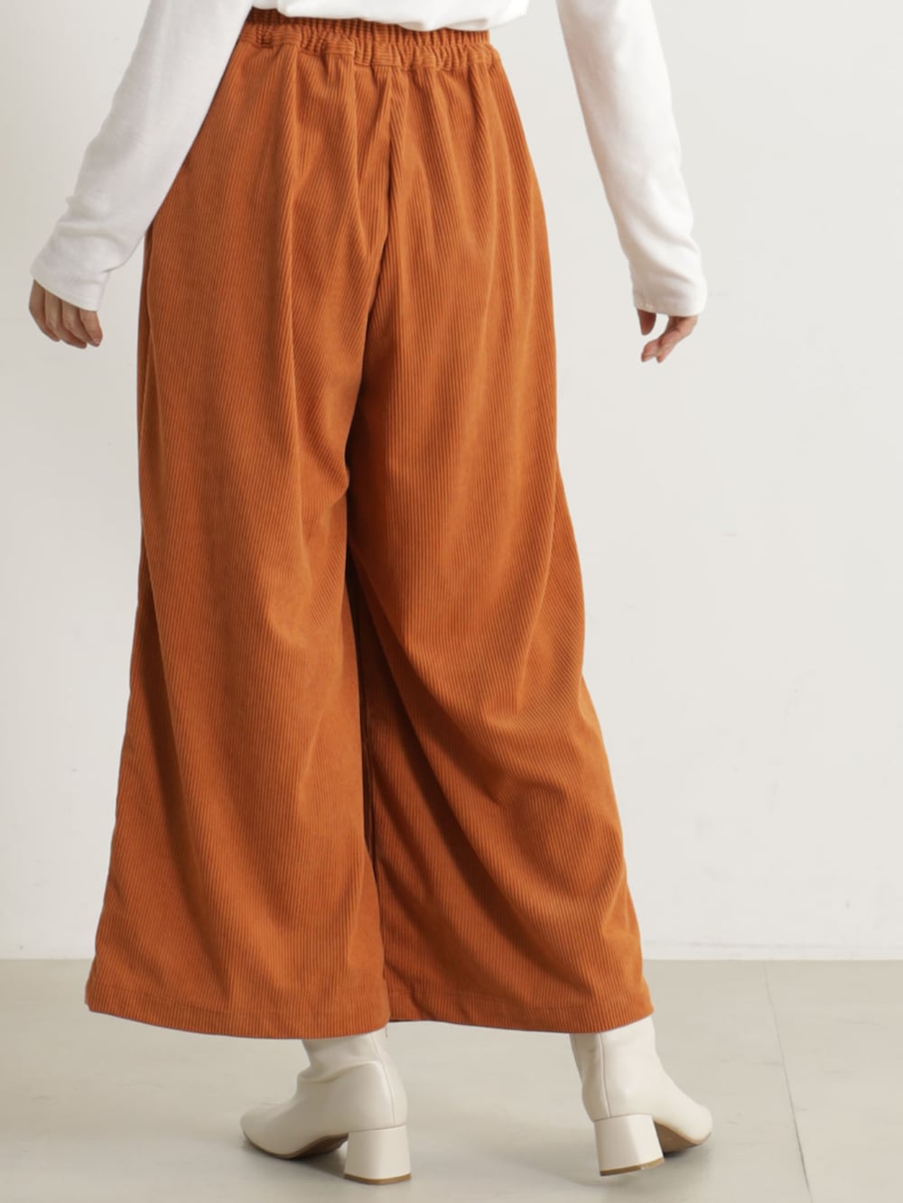 ベージュ系のブーツ、オレンジ系のその他パンツ、ベージュ系のニット/セーターを着用したレディースの冬コーディネートの4枚目の写真