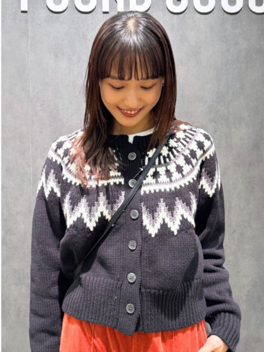 オレンジ系のその他パンツ、ブラック系のショルダーバッグ、ブラック系のニット/セーターを着用したレディースの冬コーディネートの2枚目の写真