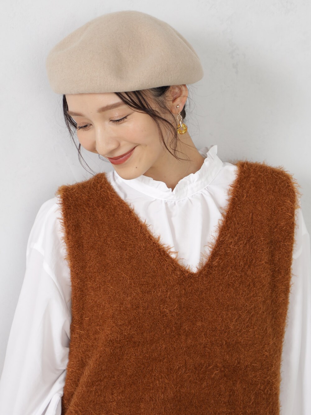 ブラウン系のニット/セーター、ベージュ系のハンチング/ベレー帽、ベージュ系のマフラーを着用したレディースの秋コーディネートの3枚目の写真