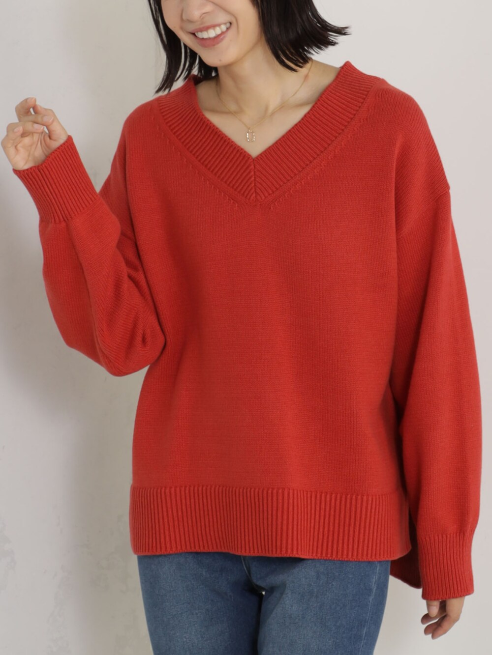 レッド系のニット/セーター、ブルー系のその他パンツを着用したレディースの冬コーディネートの2枚目の写真