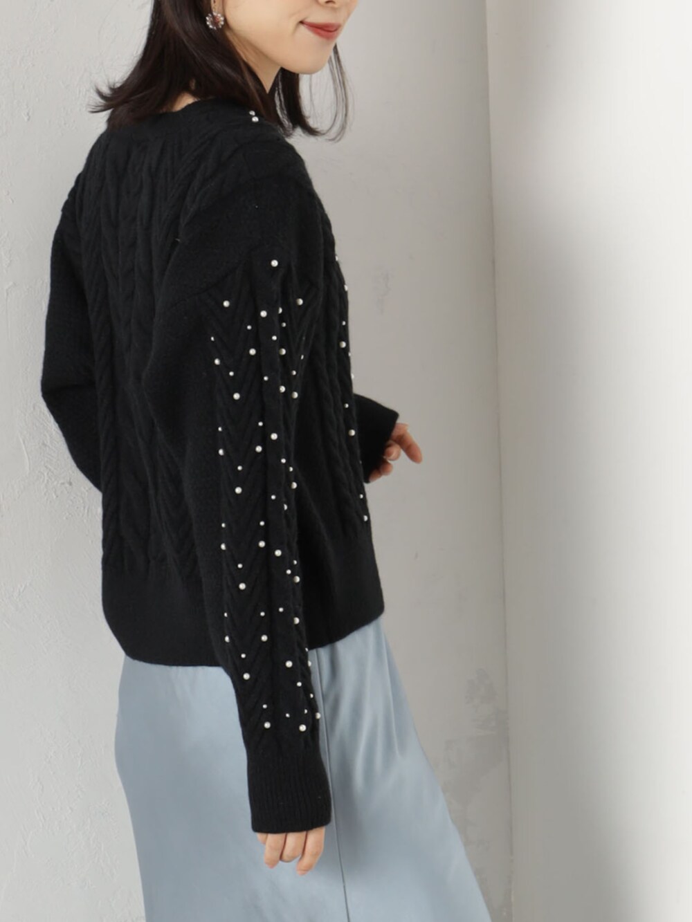 ブラック系のニット/セーター、ブルー系のスカートを着用したレディースの冬コーディネートの3枚目の写真