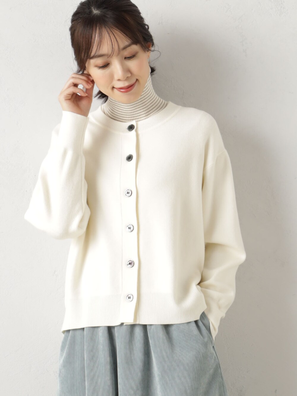 ベージュ系のカーディガン/ボレロ、ブラウン系のニット/セーターを着用したレディースの冬コーディネートの2枚目の写真