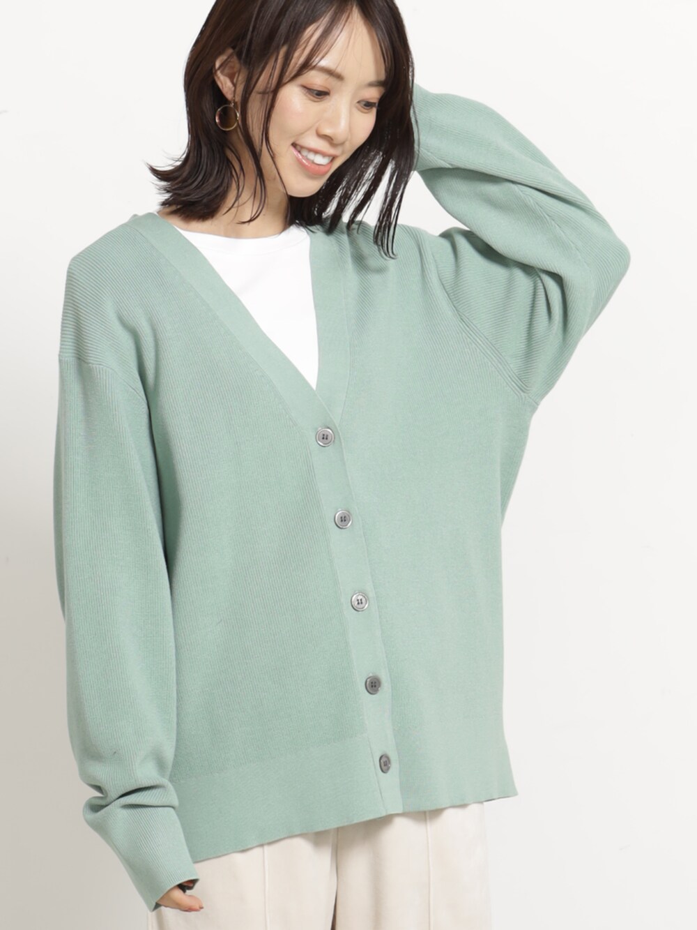 ベージュ系のその他パンツ、グリーン系のカーディガン/ボレロを着用したレディースの秋コーディネートの2枚目の写真