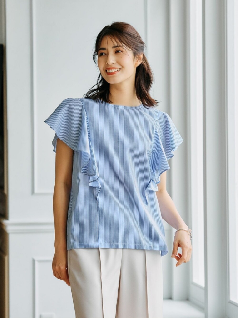 ブルー系のシャツ/ブラウスを着用したレディースの夏コーディネートの2枚目の写真