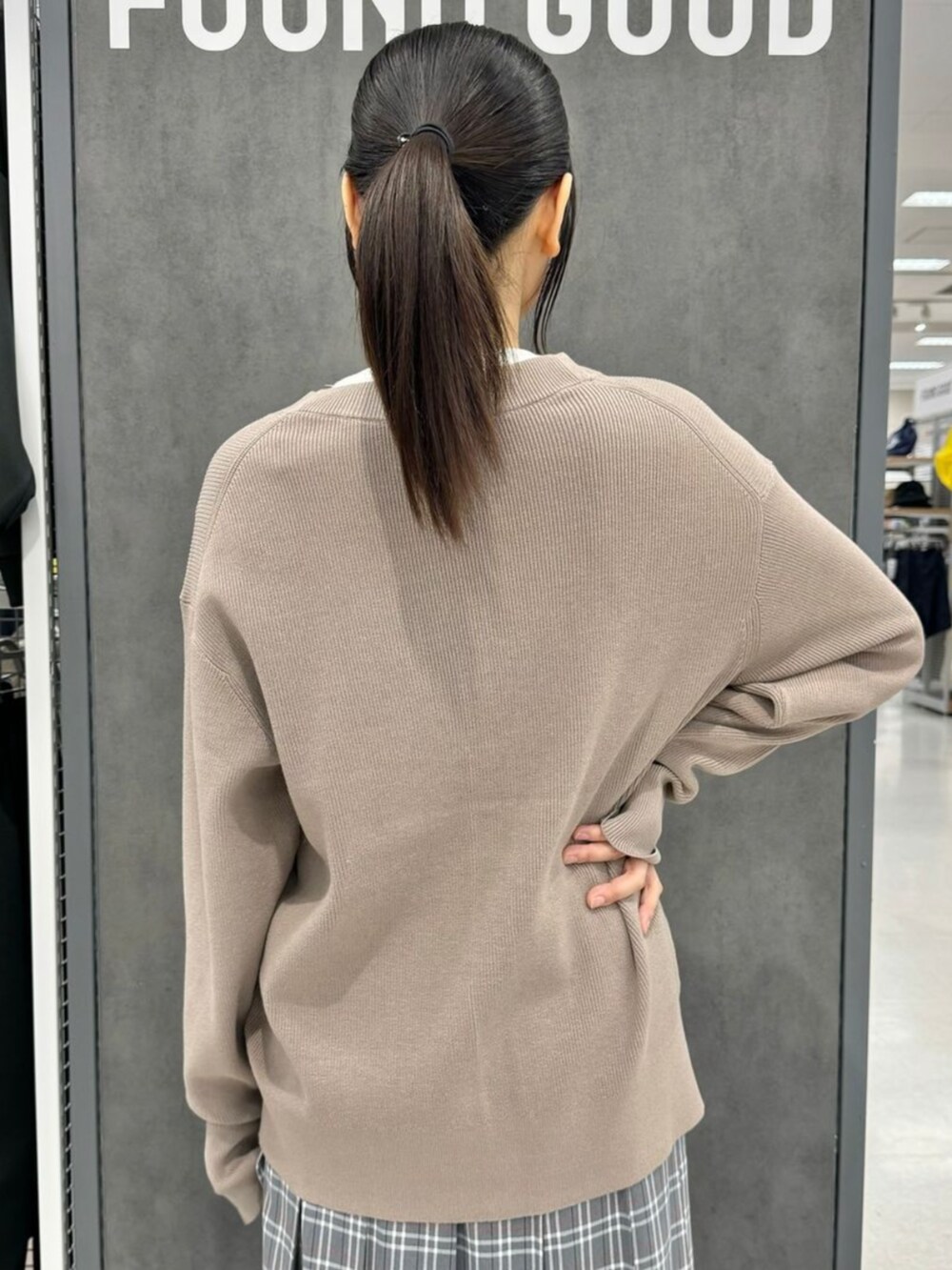 ホワイト系のTシャツ/カットソー、ベージュ系のカーディガン/ボレロ、グレー系のスカートを着用したレディースの秋コーディネートの3枚目の写真