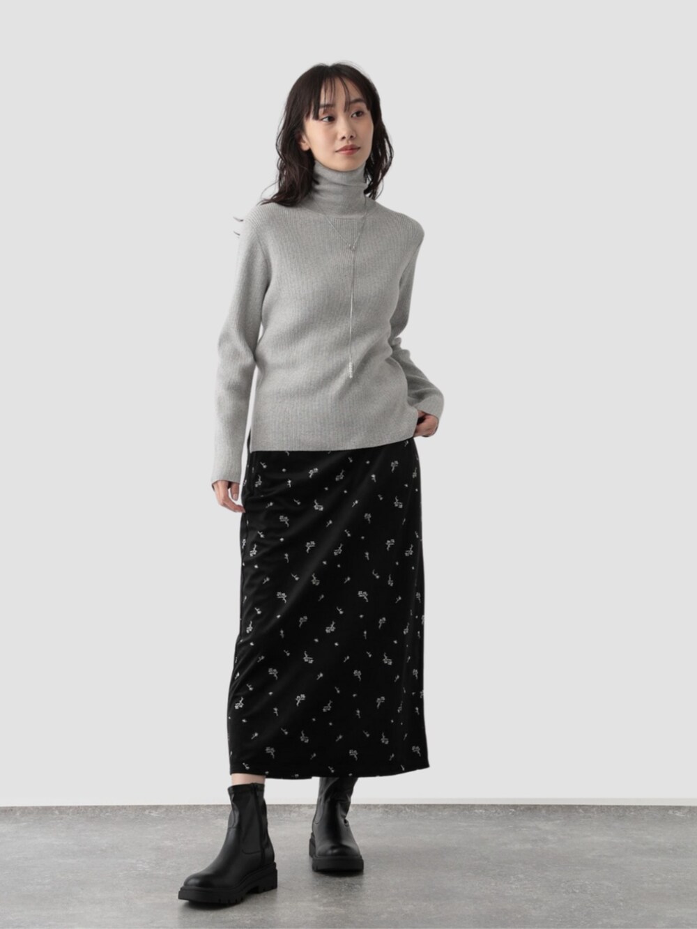 ブラック系のスカートを着用したレディースの秋コーディネートの2枚目の写真