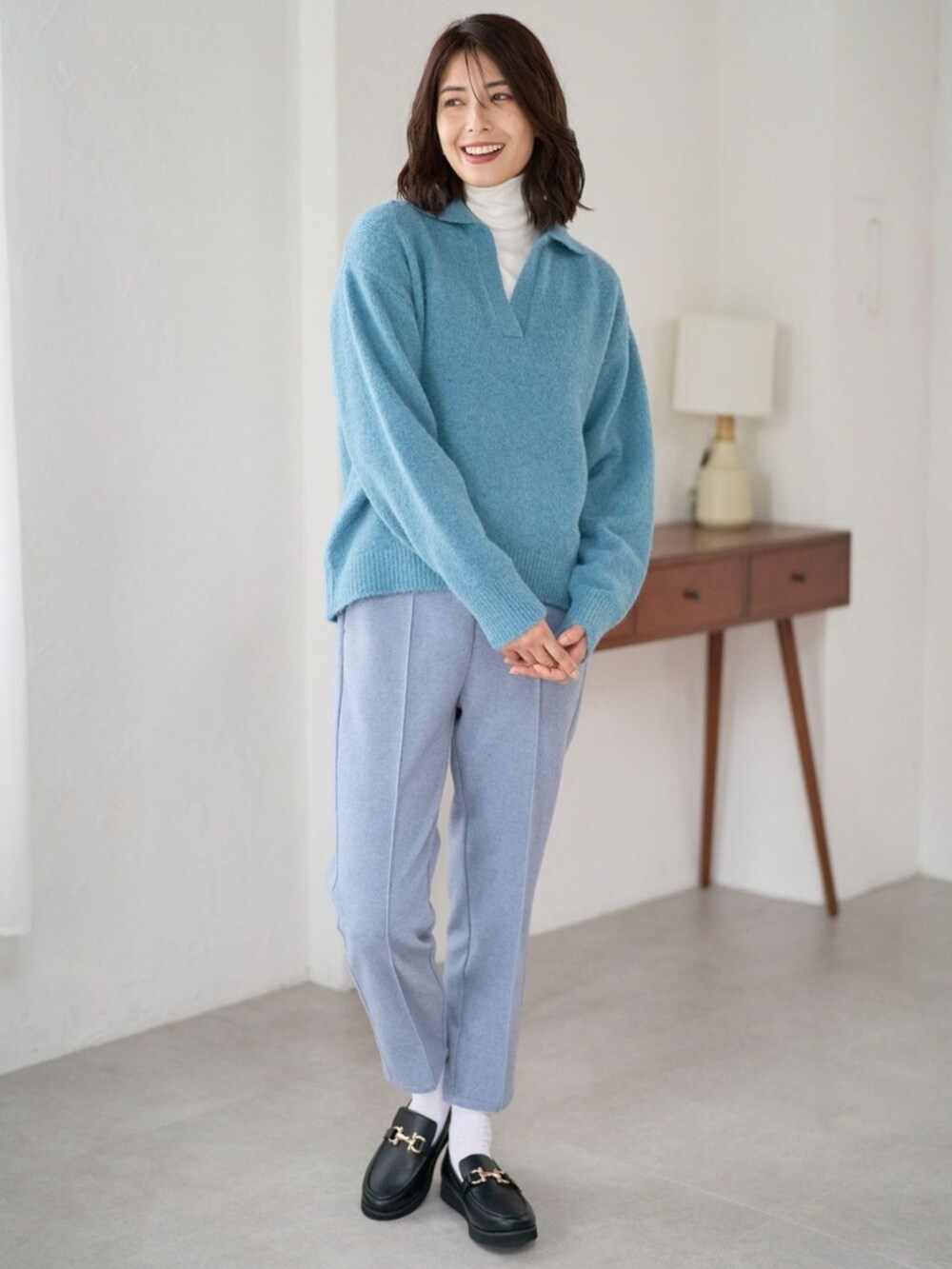 ブルー系のニット/セーターを着用したレディースの冬コーディネートの2枚目の写真