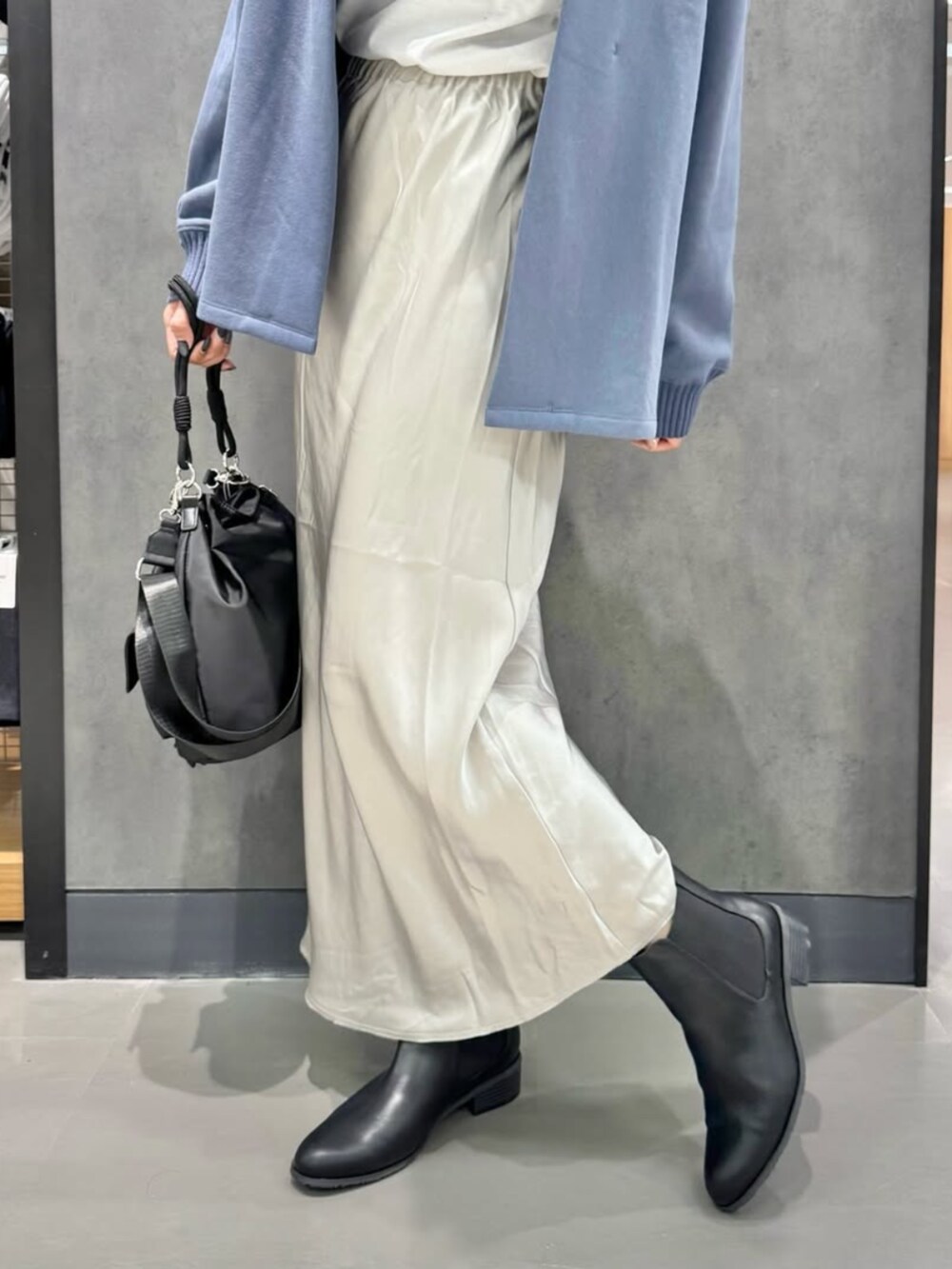 ブルー系のカーディガン/ボレロ、ホワイト系のTシャツ/カットソー、ベージュ系のスカートを着用したレディースの冬コーディネートの2枚目の写真