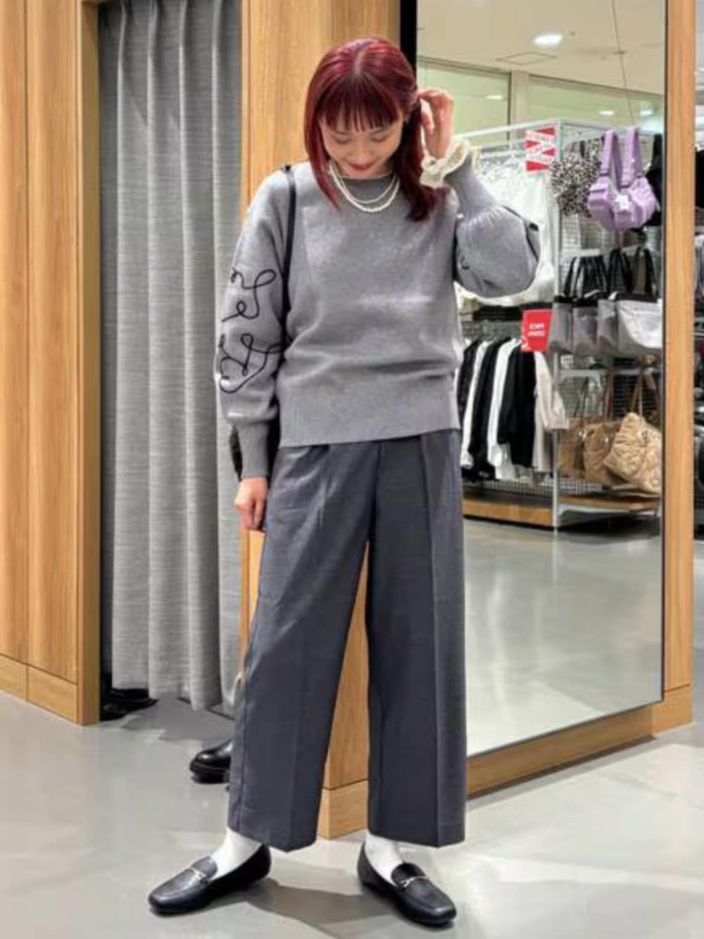 グレー系のニット/セーター、ブラック系のその他パンツを着用したレディースの冬コーディネートの2枚目の写真