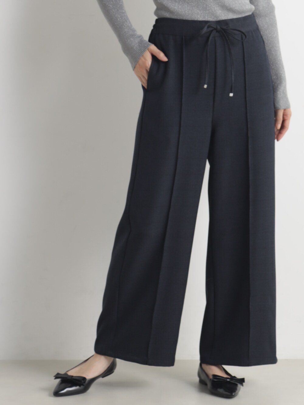 グレー系のニット/セーター、ブルー系のその他パンツを着用したレディースの冬コーディネートの2枚目の写真