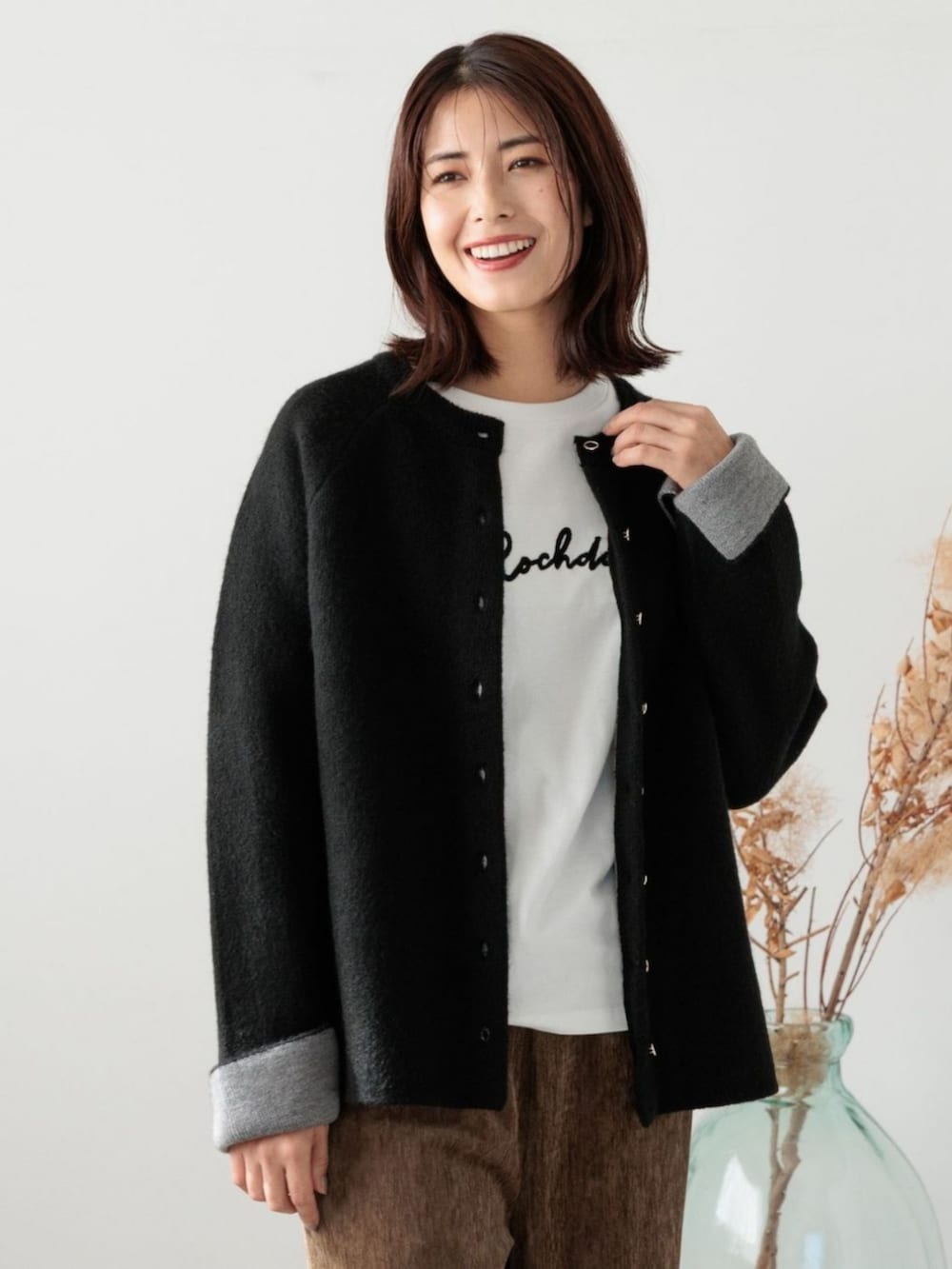 ブラック系のカーディガン/ボレロを着用したレディースの冬コーディネートの2枚目の写真