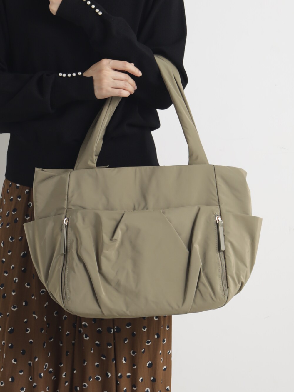 ベージュ系のトートバッグを着用したレディースの冬コーディネートの3枚目の写真