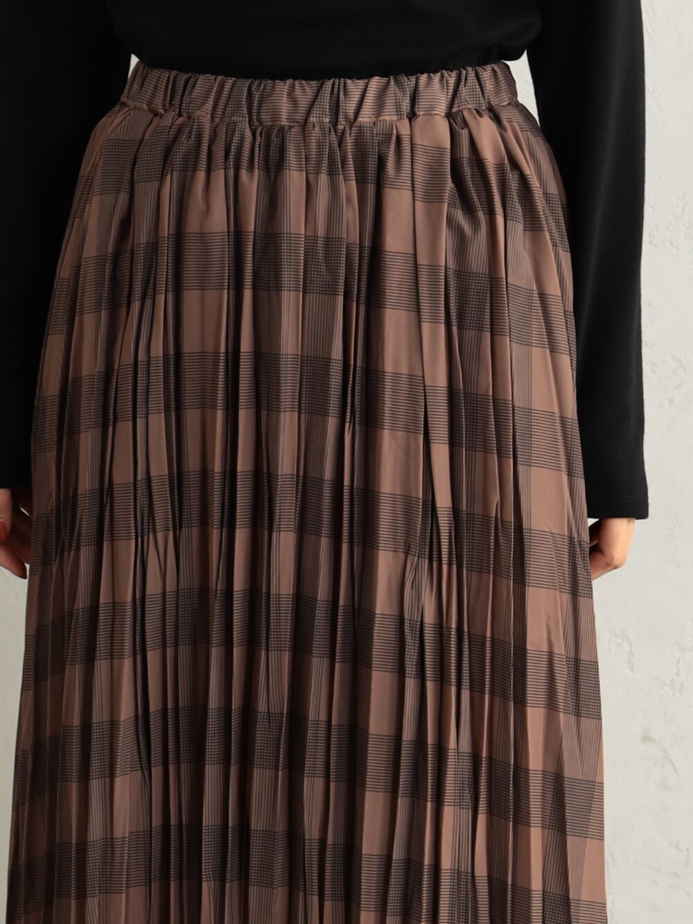 ブラック系のブーツ、ブラック系のニット/セーター、ブラウン系のスカートを着用したレディースの冬コーディネートの3枚目の写真