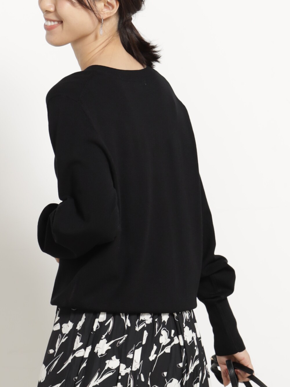 ブラック系のニット/セーター、ブラック系のショルダーバッグを着用したレディースの秋コーディネートの2枚目の写真