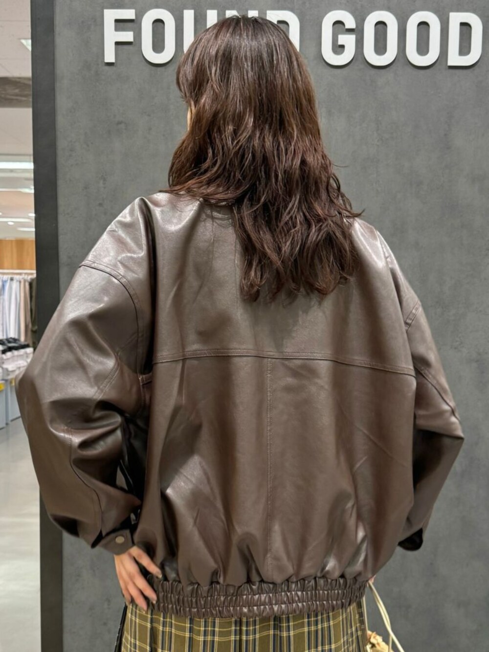 グリーン系のスカート、ブラウン系のブルゾン、ベージュ系のスウェットを着用したレディースの秋コーディネートの3枚目の写真