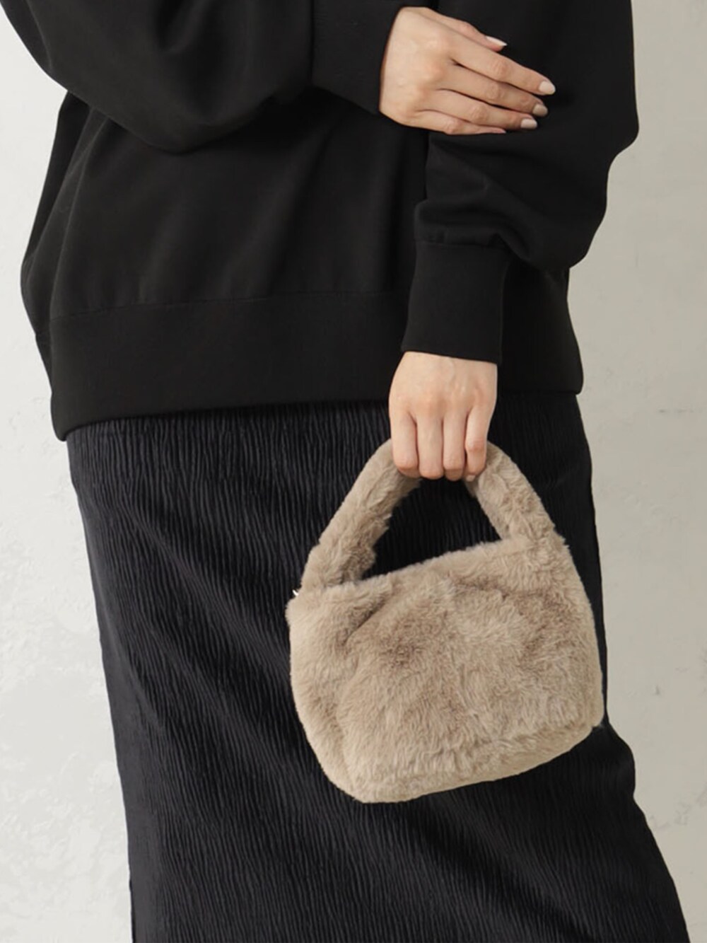 ベージュ系のハンドバッグ、ホワイト系のその他トップスを着用したレディースの冬コーディネートの2枚目の写真