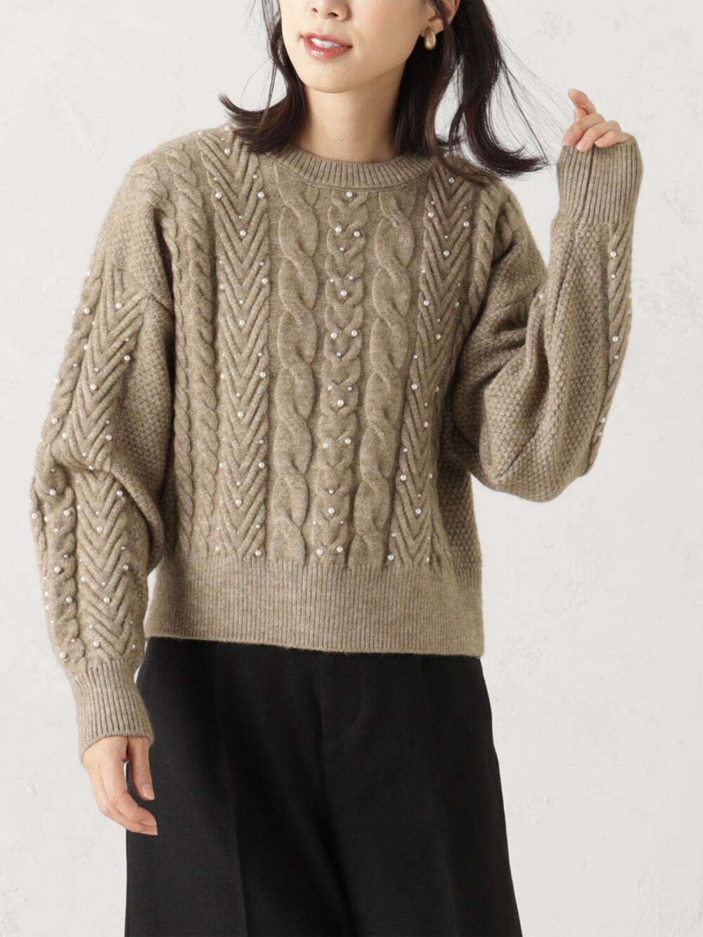 ブラウン系のその他パンツ、ベージュ系のニット/セーターを着用したレディースの冬コーディネートの2枚目の写真