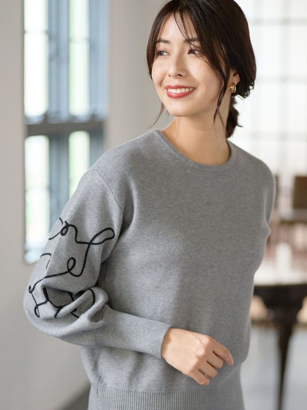 グレー系のニット/セーターを着用したレディースの秋コーディネートの2枚目の写真