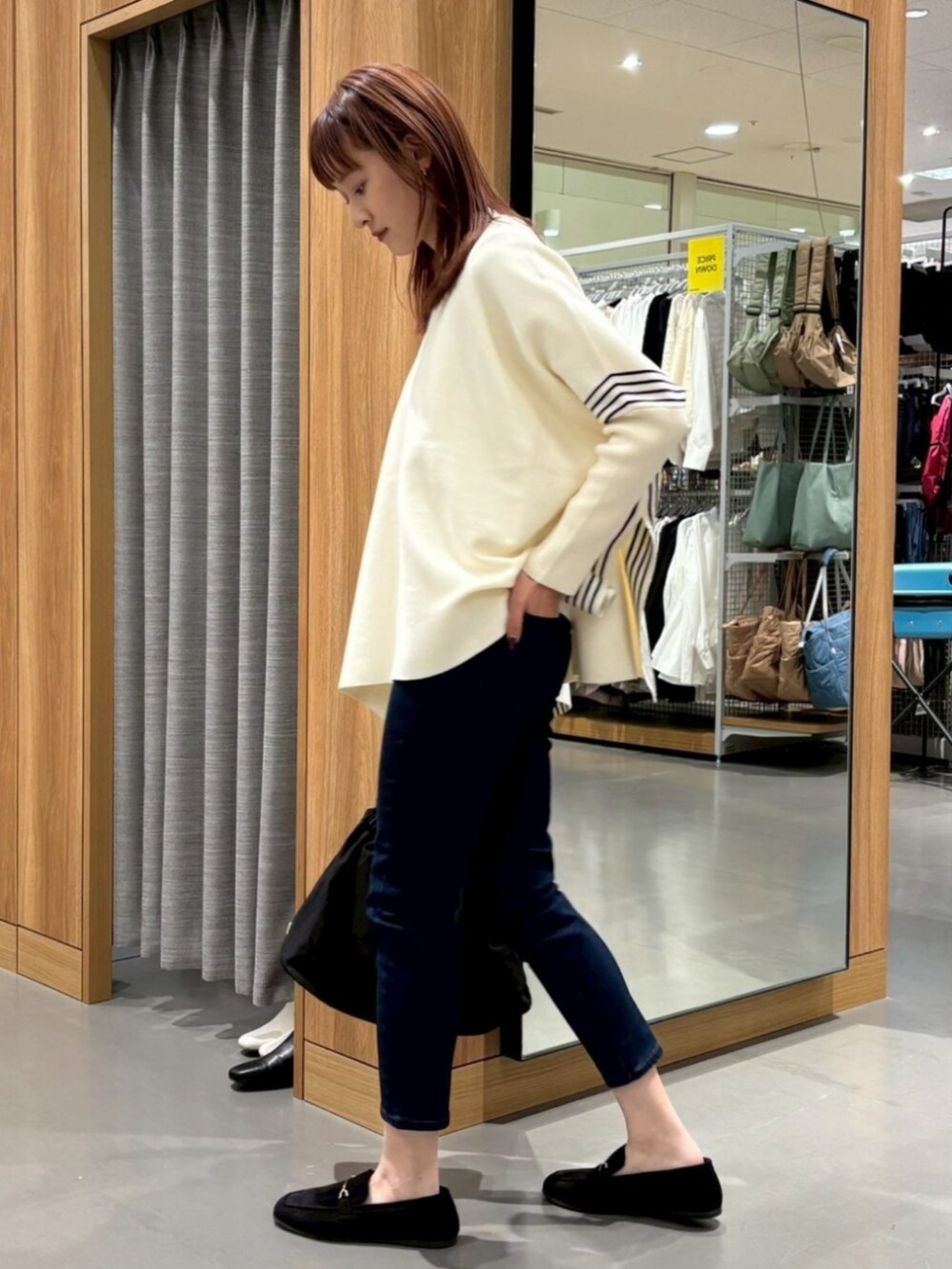 ベージュ系のポンチョを着用したレディースの冬コーディネートの3枚目の写真