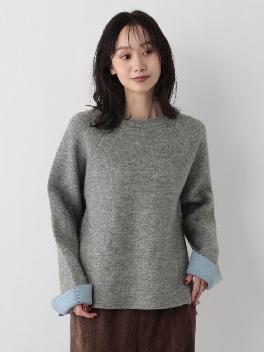 グレー系のニット/セーターを着用したレディースの冬コーディネートの2枚目の写真