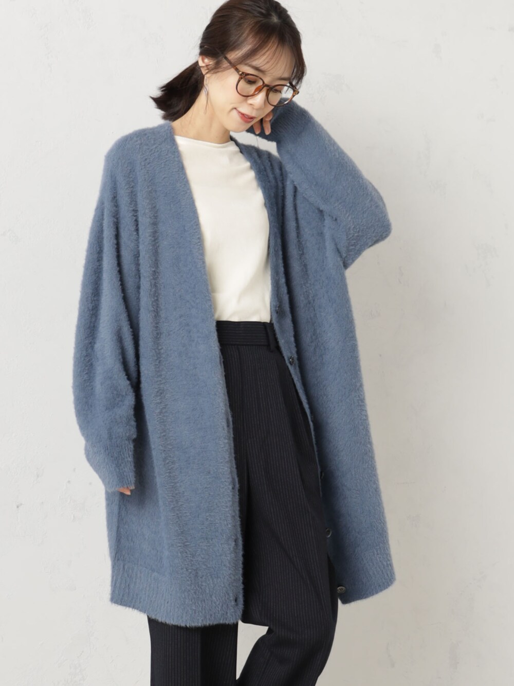 ブルー系のカーディガン/ボレロを着用したレディースの冬コーディネートの2枚目の写真