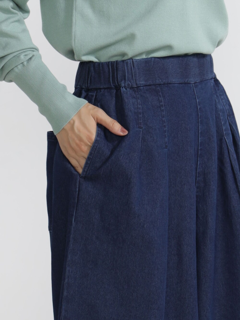 グリーン系のニット/セーター、ベージュ系のチノパンツを着用したレディースの秋コーディネートの3枚目の写真