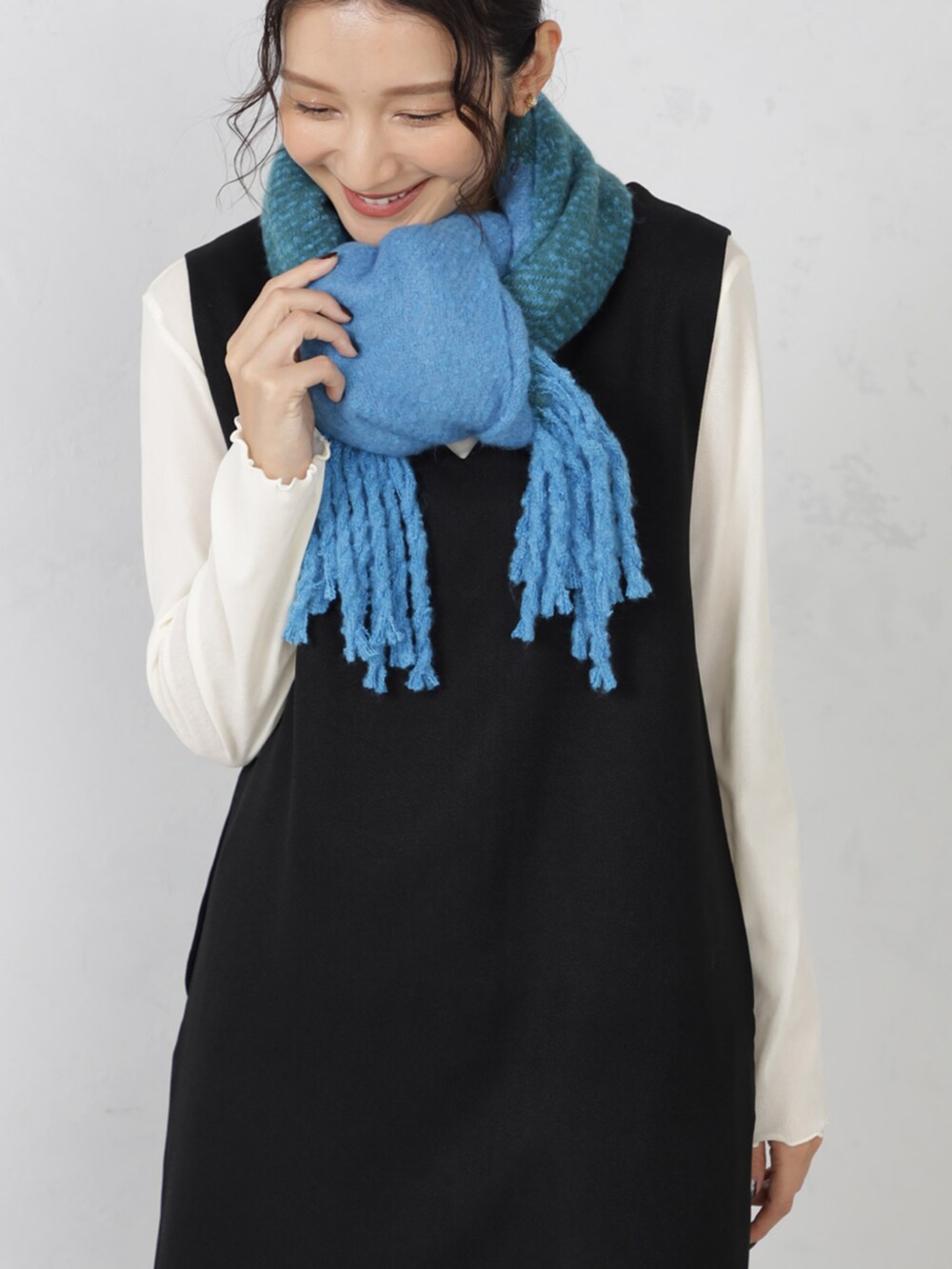 ブラック系のワンピース、グリーン系のマフラーを着用したレディースの秋コーディネートの2枚目の写真