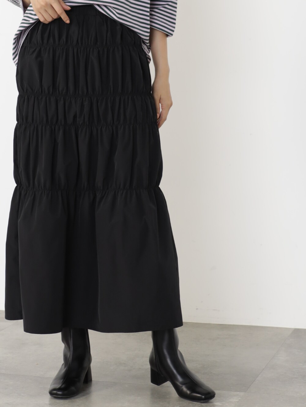 ブラウン系のニット/セーター、ブラック系のスカートを着用したレディースの秋コーディネートの2枚目の写真