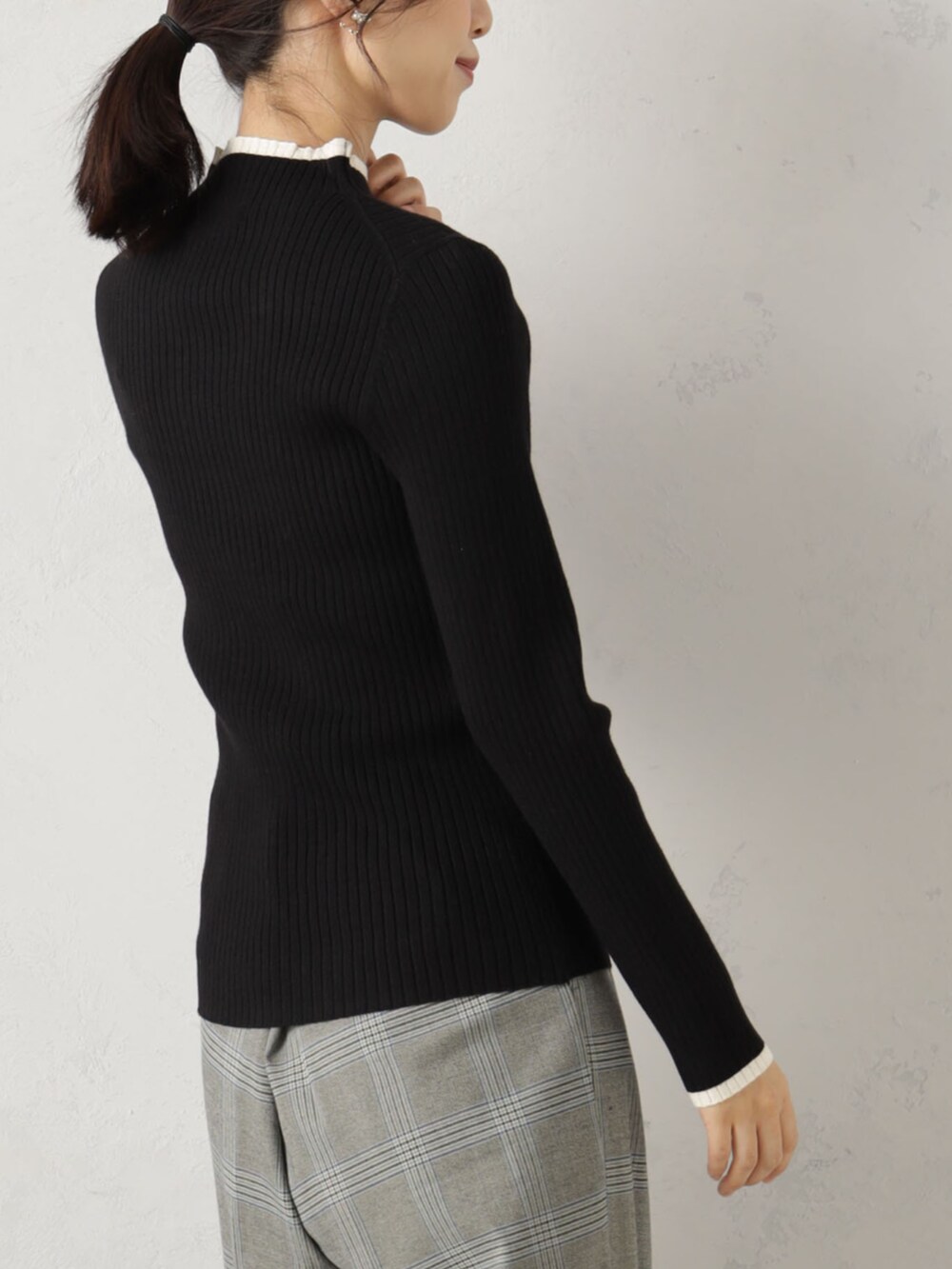 ブラック系のニット/セーターを着用したレディースの冬コーディネートの2枚目の写真