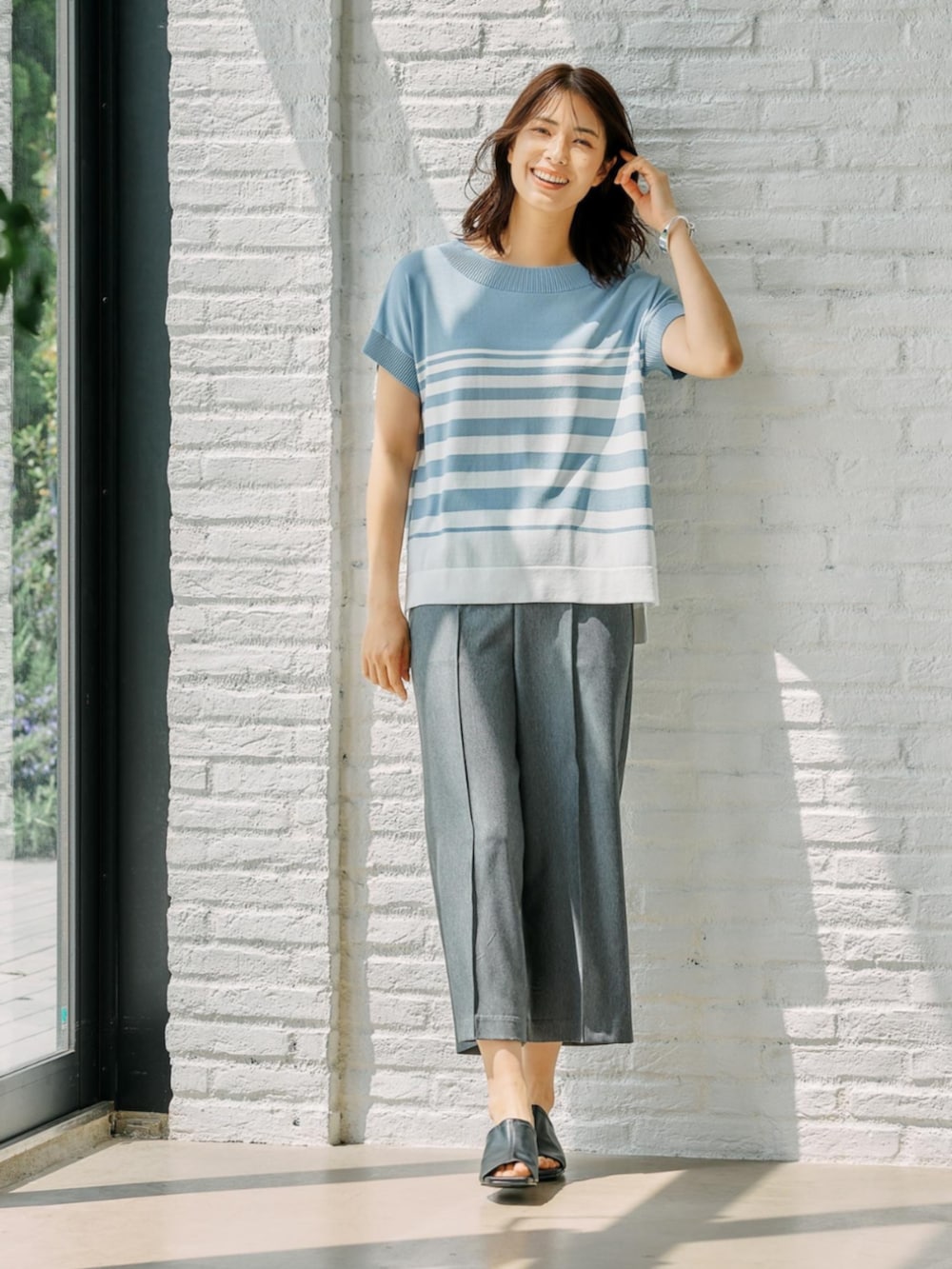 ブルー系のニット/セーターを着用したレディースの春コーディネートの2枚目の写真